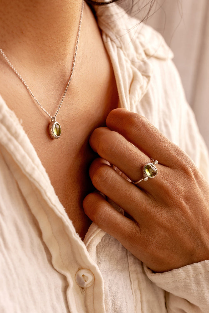 Natural Oval Cabochon light green Peridot and two lab-grown diamonds in an organic style sterling silver ring, and a matching pendant.