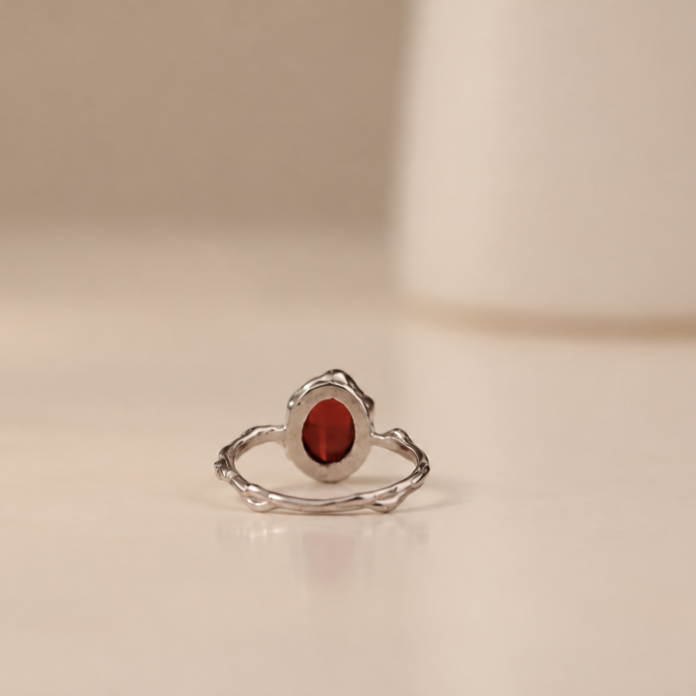 Organic sterling silver ring with a single dark red garnet oval cabochon, handmade by Rooz Jewellery
