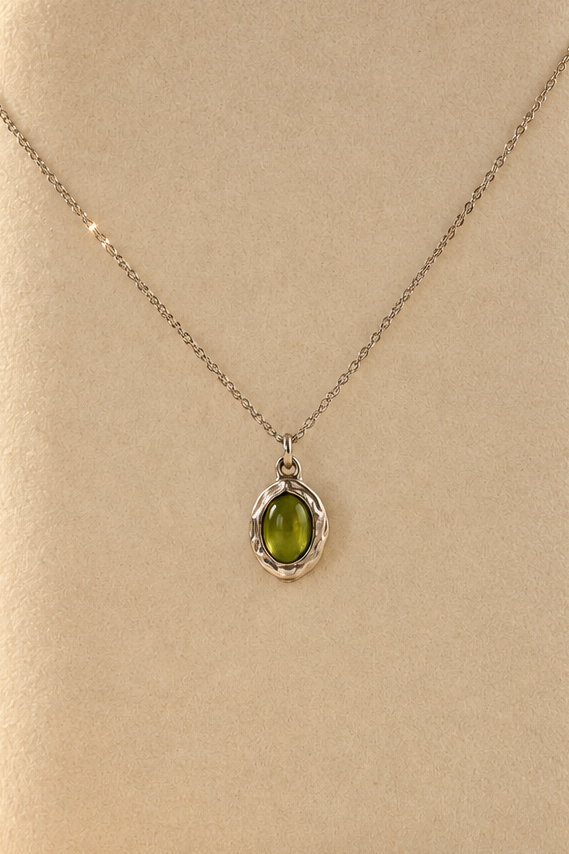 Organic sterling silver pendant with a vivid green oval peridot cabochon, handmade by Rooz Jewellery in Toronto