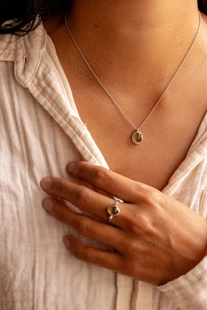 Natural Oval Cabochon light green Peridot and two lab-grown diamonds in an organic style sterling silver ring and a matching pendant.