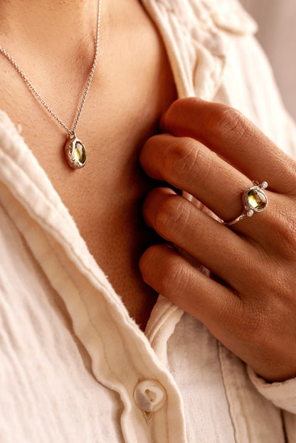Natural Oval Cabochon light green Peridot and two lab-grown diamonds in an organic style sterling silver ring, and a matching pendant.