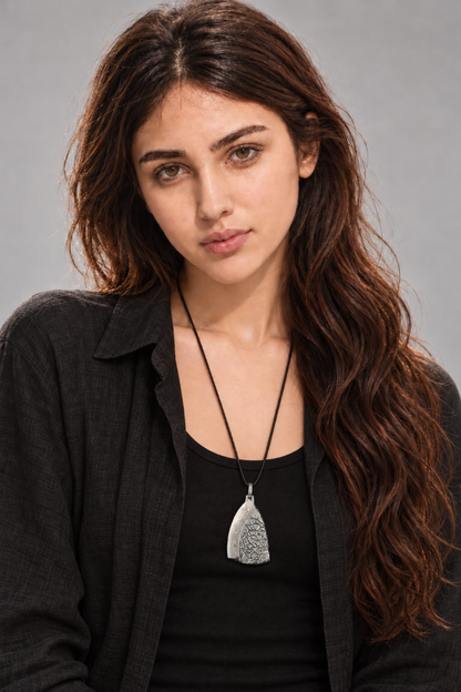 Handmade ancient Iranian inspired sterling silver pendant from the Shards Collection by Rooz Jewellery, half polished and half patterned with a Persian lattice of petals and dots, on a black genuine leather cord over ceramic fragments