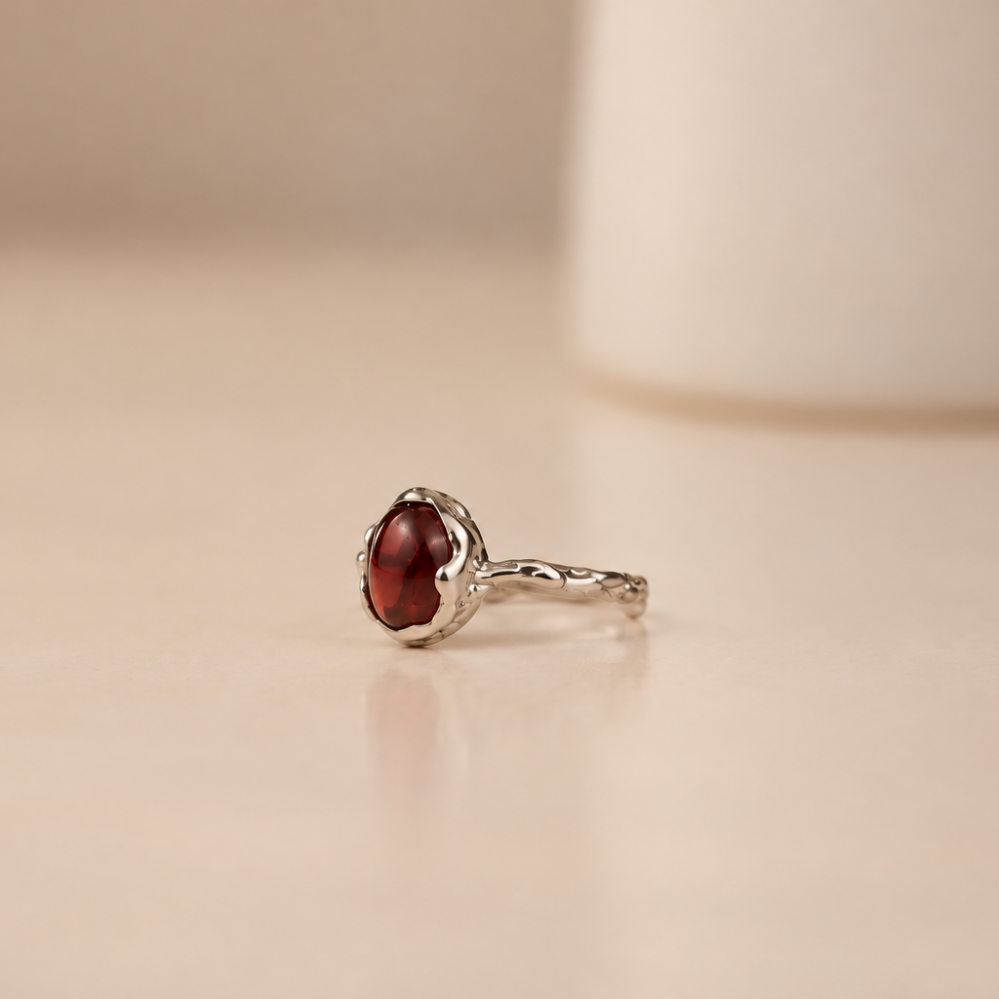 Organic sterling silver ring with a single dark red garnet oval cabochon, handmade by Rooz Jewellery
