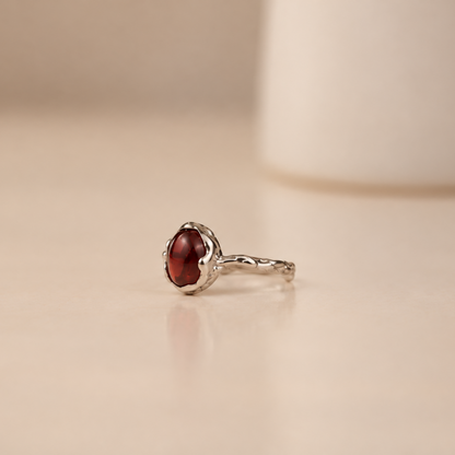 Organic sterling silver ring with a single dark red garnet oval cabochon, handmade by Rooz Jewellery