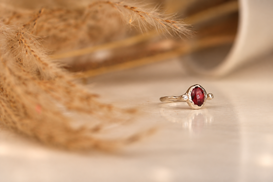 Handmade organic sterling silver ring with a deep red oval garnet and small lab-grown diamonds, Rooz Jewellery Toronto