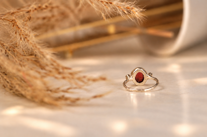 Handmade organic sterling silver ring with a deep red oval garnet and small lab-grown diamonds, Rooz Jewellery Toronto