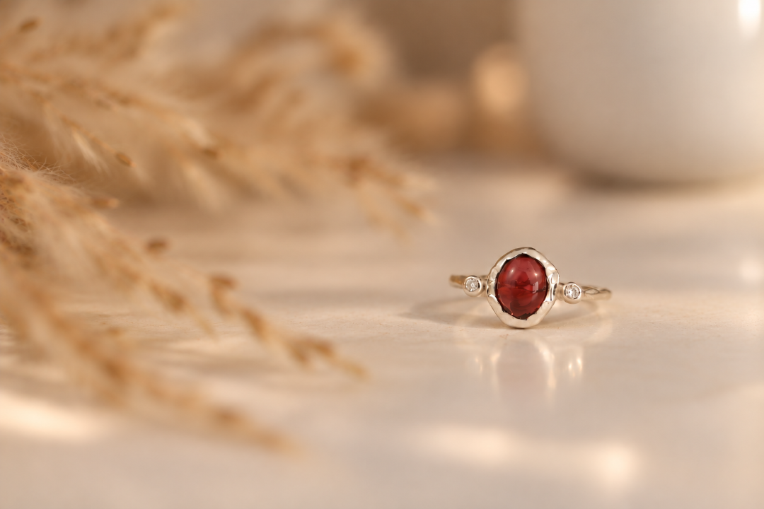 Handmade organic sterling silver ring with a deep red oval garnet and small lab-grown diamonds, Rooz Jewellery Toronto