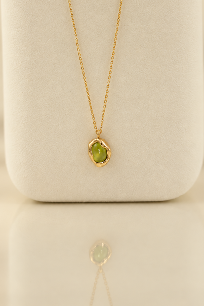 Organic solid 10k gold pendant with a green oval peridot cabochon, handmade by Rooz Jewellery in Toronto