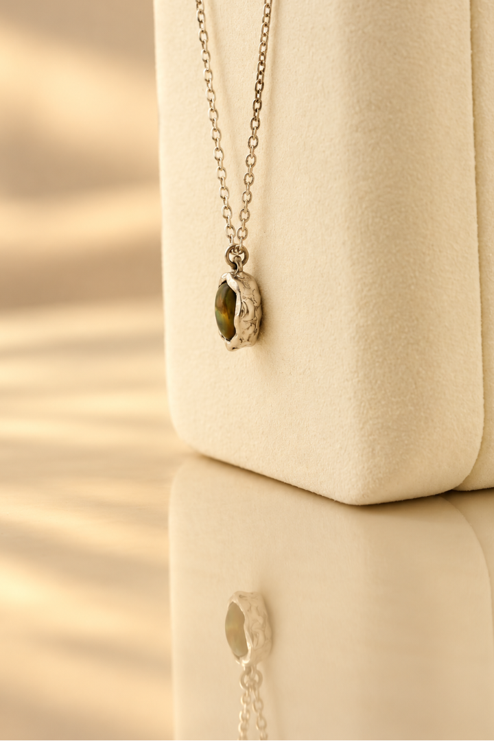 Organic sterling silver pendant with an iridescent peacock-feather mother of pearl oval cabochon, handmade by Rooz Jewellery