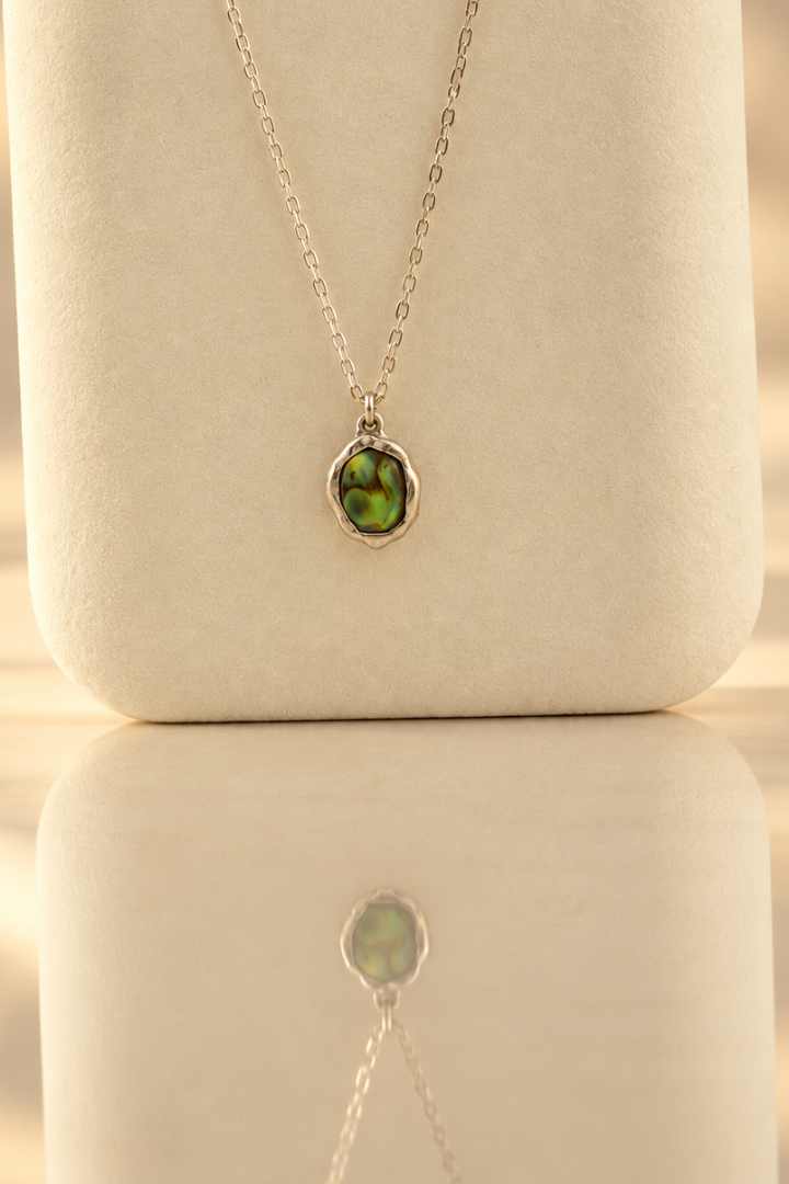 Organic sterling silver pendant with an iridescent peacock-feather mother of pearl oval cabochon, handmade by Rooz Jewellery