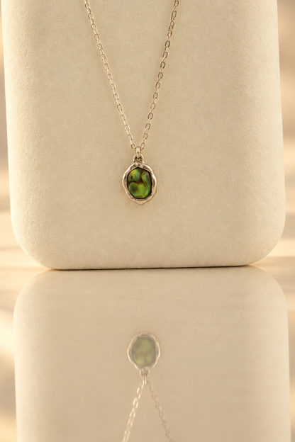 Organic sterling silver pendant with an iridescent peacock-feather mother of pearl oval cabochon, handmade by Rooz Jewellery
