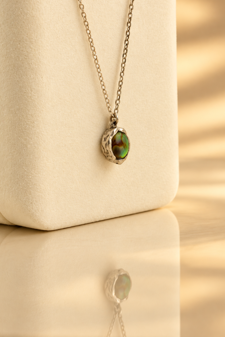 Organic sterling silver pendant with an iridescent peacock-feather mother of pearl oval cabochon, handmade by Rooz Jewellery