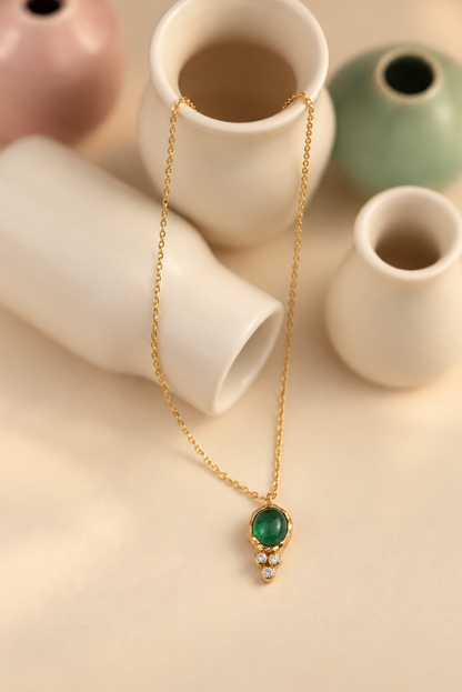 Organic solid 10k gold pendant with a green emerald cabochon and three small lab-grown diamonds, Rooz Jewellery Toronto