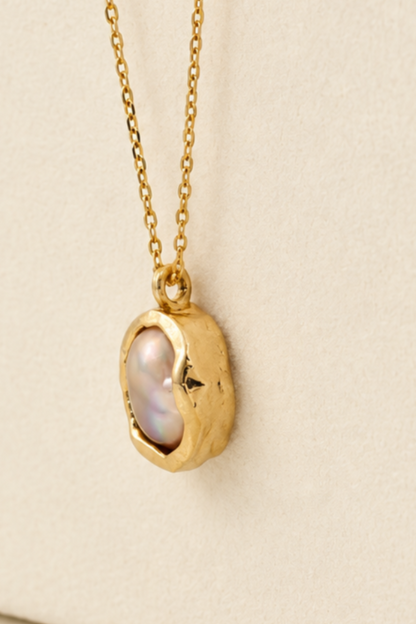 Organic solid 10k gold pendant with an irregular natural freshwater pearl on a gold chain, handmade by Rooz Jewellery