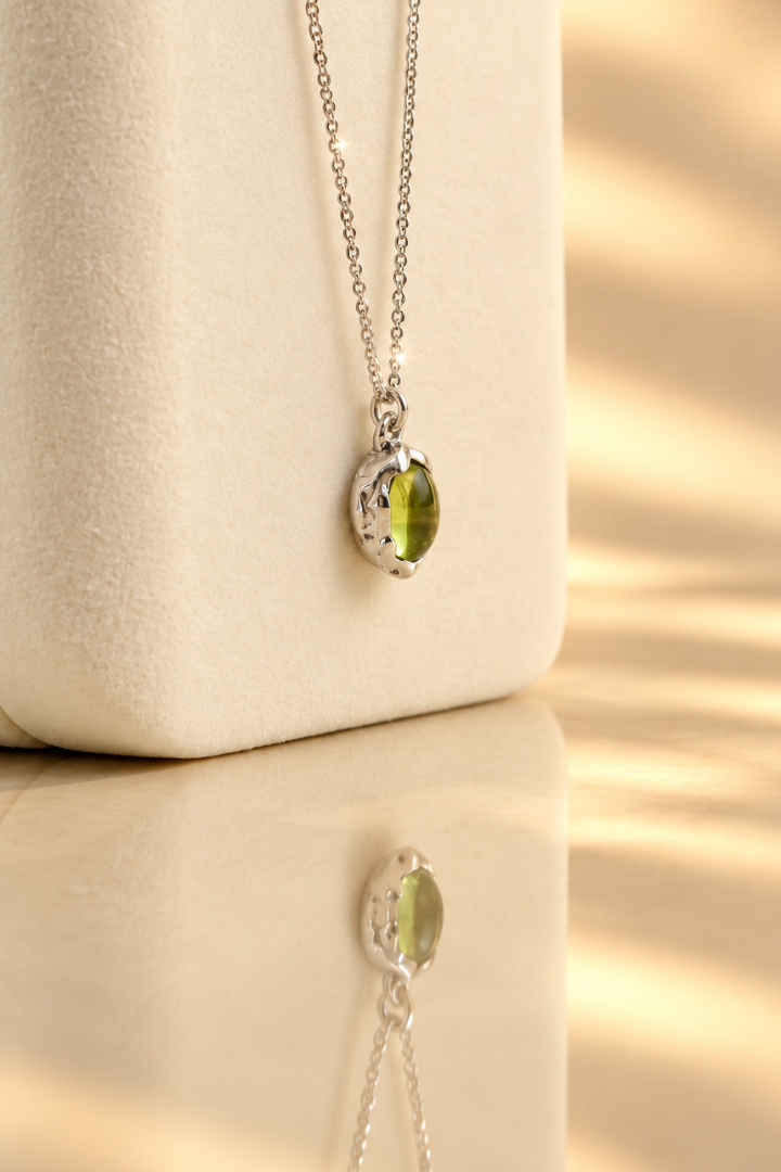 Organic sterling silver pendant with a vivid green oval peridot cabochon, handmade by Rooz Jewellery in Toronto
