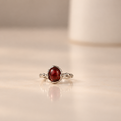 Organic sterling silver ring with a single dark red garnet oval cabochon, handmade by Rooz Jewellery
