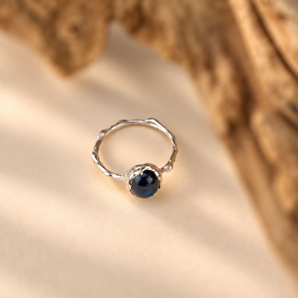 Organic sterling silver ring with a single deep blue sapphire oval cabochon, handmade by Rooz Jewellery